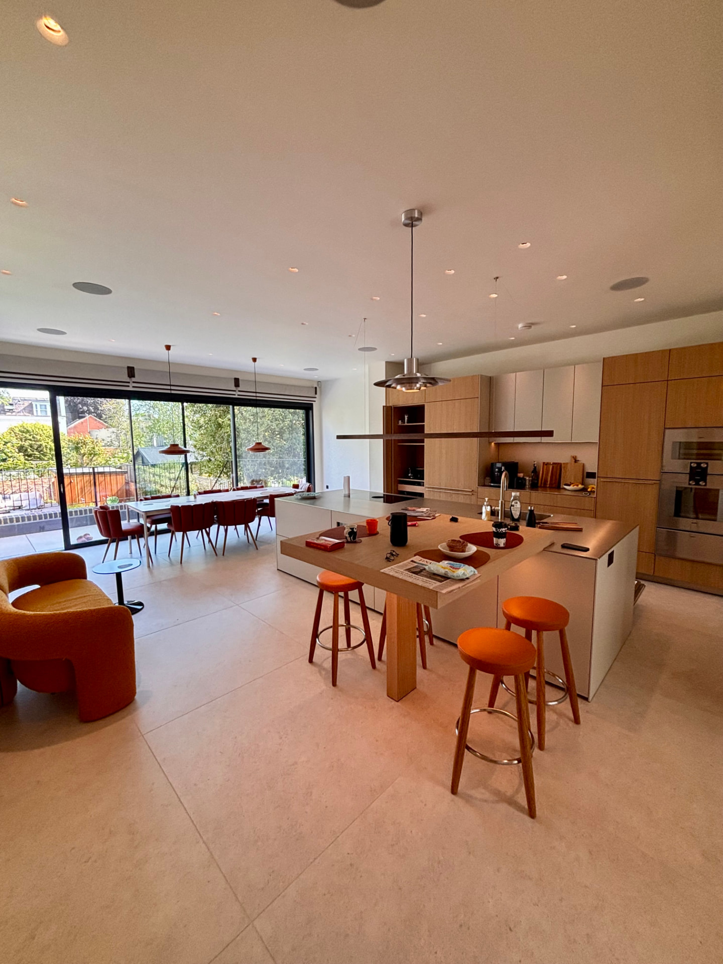 Open-plan kitchen and dining space in a Cheltenham townhouse with plaster-in downlights, pendants and ceiling speakers